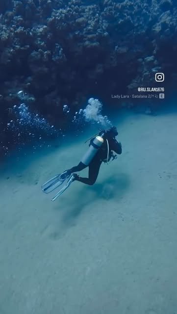 Diver gliding over the sand slope
